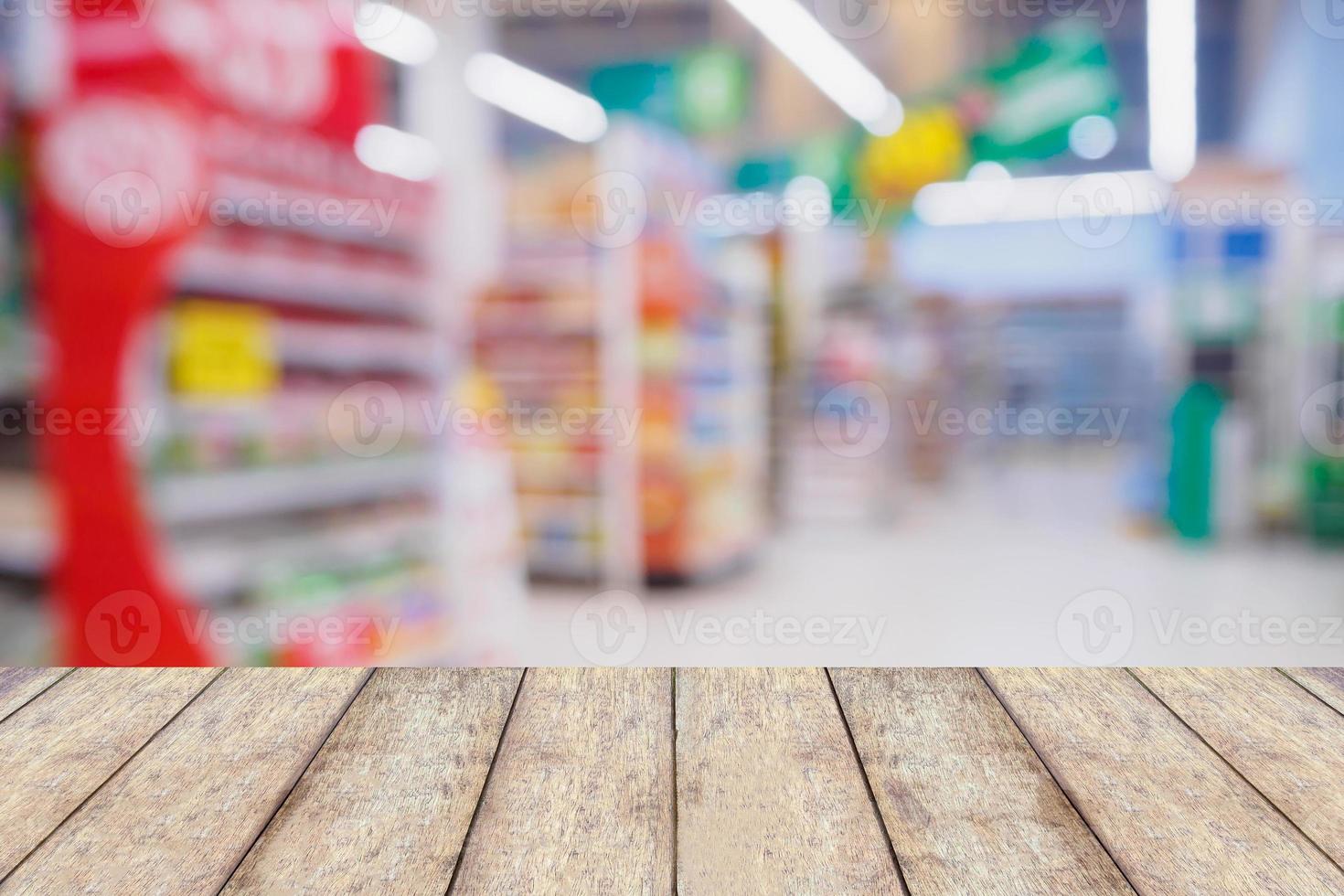 Wood table with Abstract blurred supermarket aisle and shelves photo