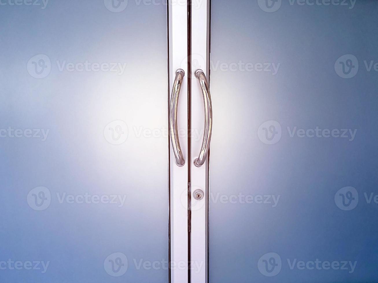 Glassdoors or front doors of the office which has stainless handlebars on their frame, soft and selective focus. photo