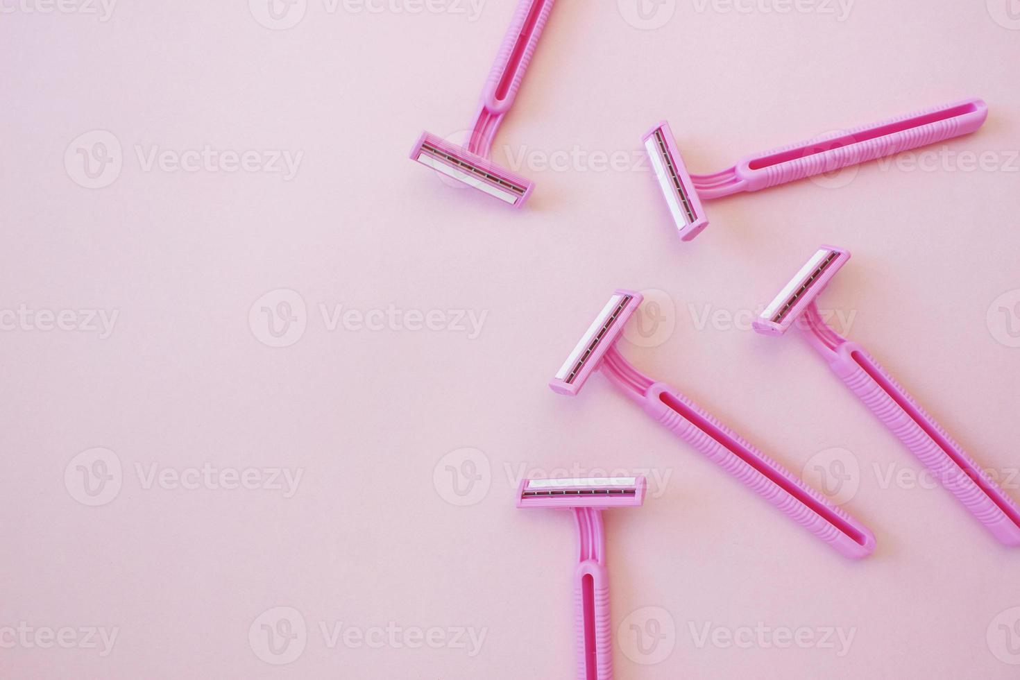 Disposable female razor on a pink background. A tool to remove hair from the skin. Female depilation and hygiene. Body care. Top view, copy space, stylish magazine concept photo