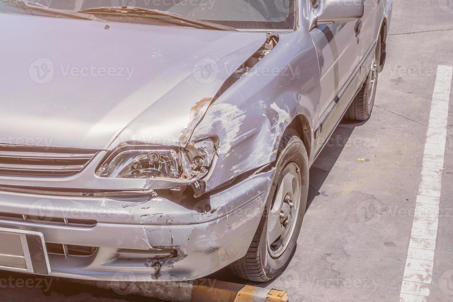 coche dañado en la causa delantera por accidente de coche en la carretera foto