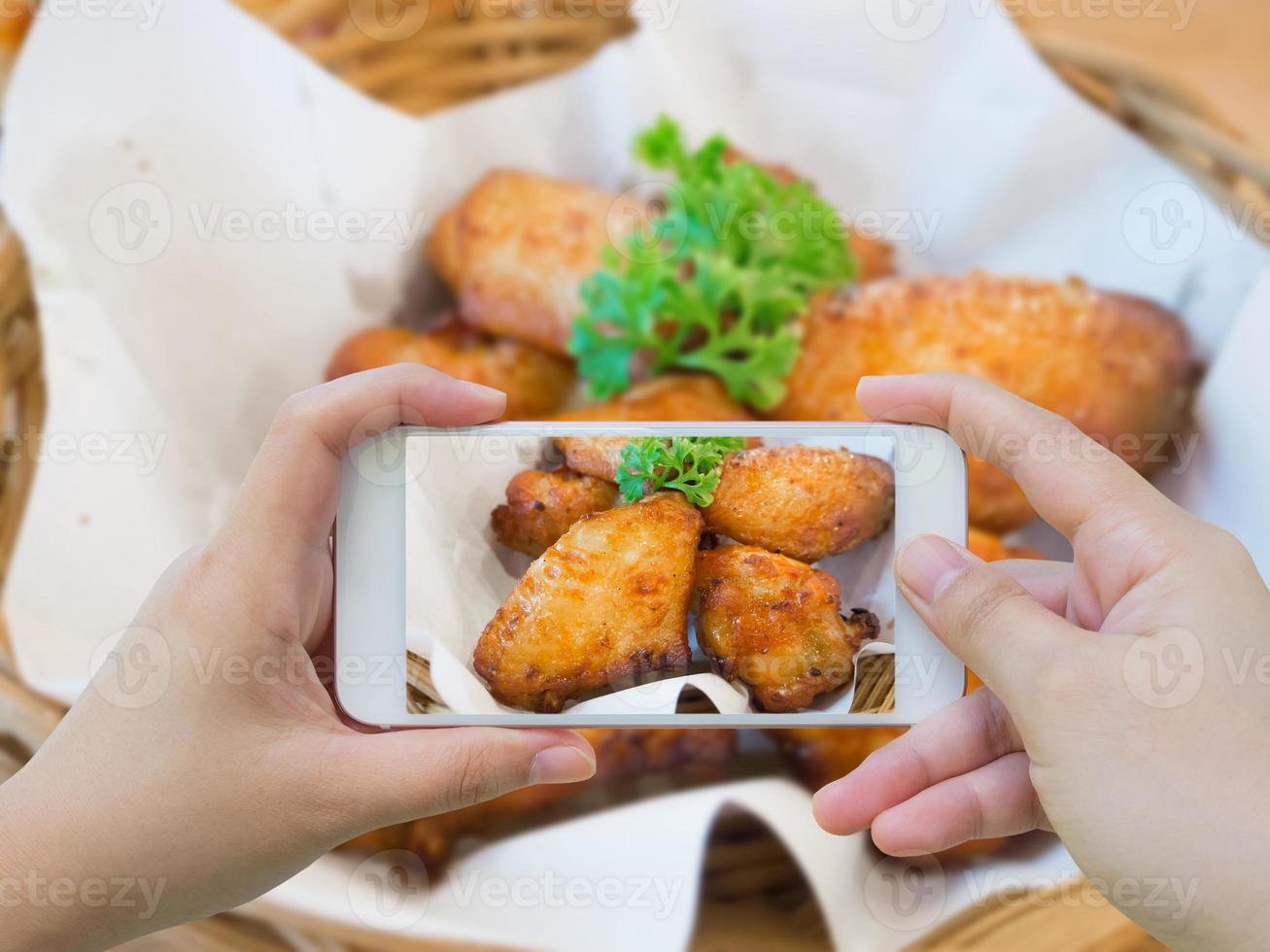 taking photo of hot and spicy chicken wings with smartphone