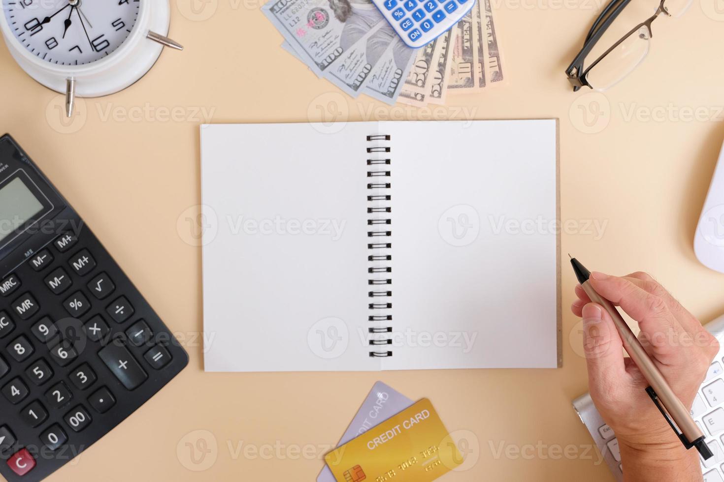 Office desk with smartphone, laptop computer, cup of coffee, and office tools. Flat lay, top view with copy space. A bank notepad and a pen are on top of an office desk table containing computer tools photo