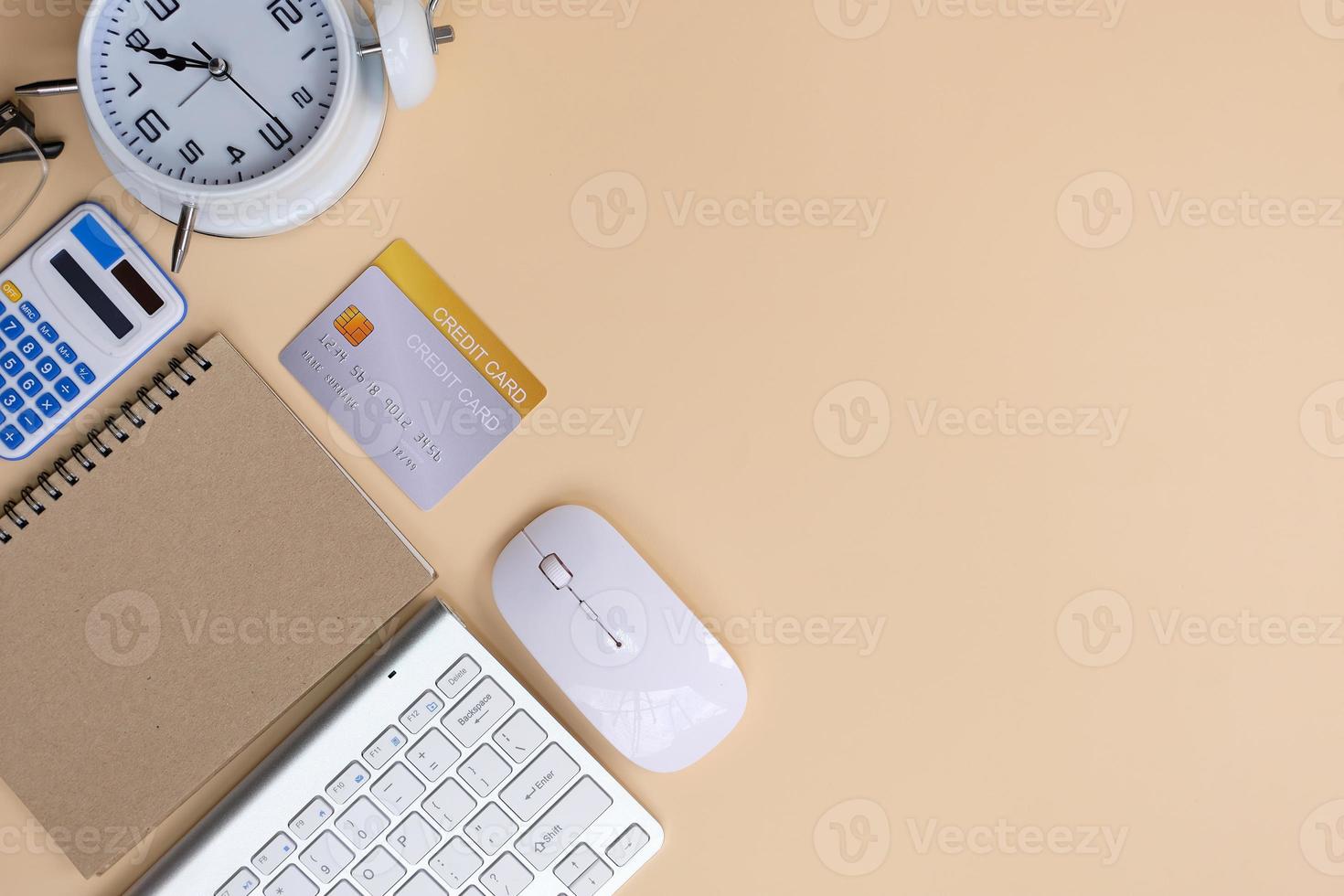 Office desk with smartphone, laptop computer, cup of coffee, and office tools. Flat lay, top view with copy space. A bank notepad and a pen are on top of an office desk table containing computer tools photo