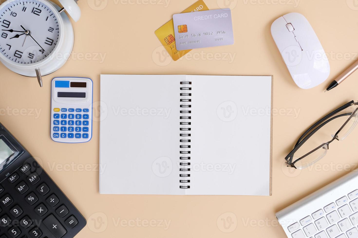 Office desk with smartphone, laptop computer, cup of coffee, and office tools. Flat lay, top view with copy space. A bank notepad and a pen are on top of an office desk table containing computer tools photo