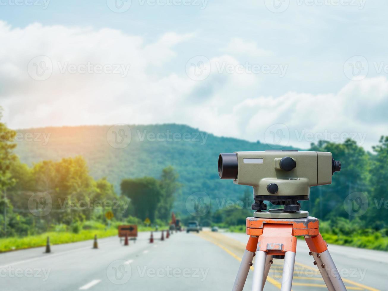 Tacómetro o teodolito del equipo topógrafo con fondo de obra de construcción de carreteras foto