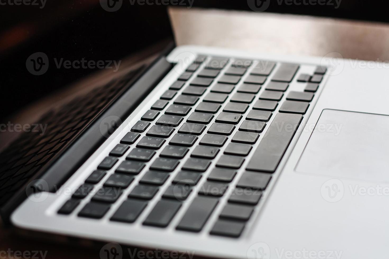 open laptop with black screen on modern wooden desk photo