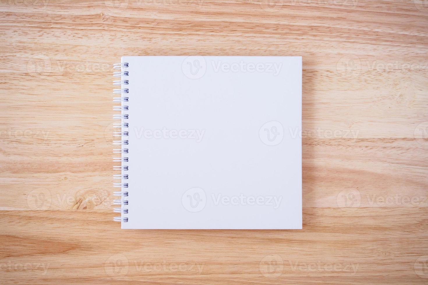 white cover notebook on brown wood desk background photo