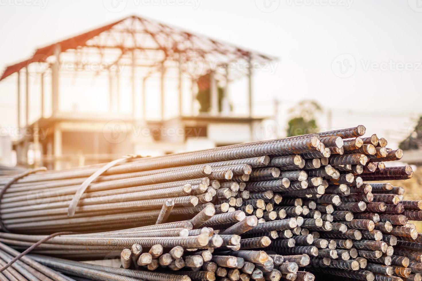 steel rebar for reinforcement concrete at construction site with house under construction background photo