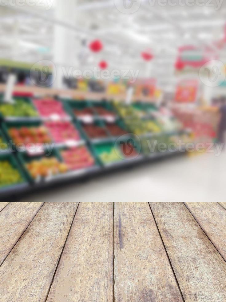 wood counter product display with fruits shelves in supermarket blurred background photo