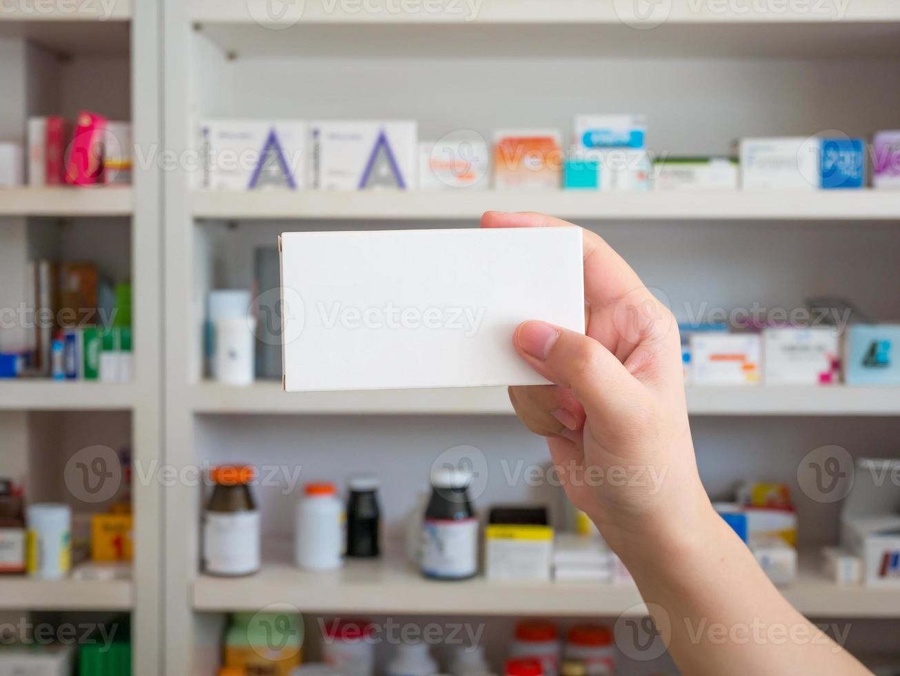 Close up pharmacist hand hold medicine box package photo