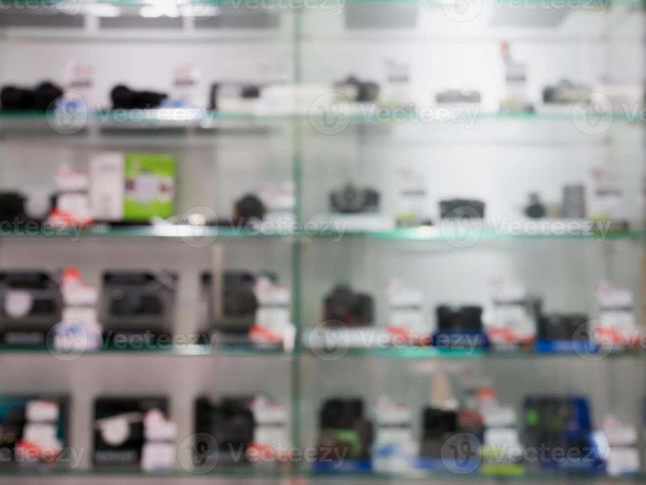 cámaras digitales y lentes en el estante de la tienda de cámaras desenfoque de fondo foto