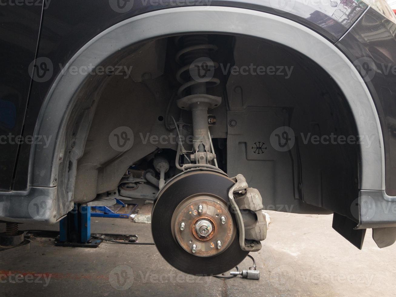 Lift is lifting a black car, removing the wheels, a car suspension repair concept. tire change. photo