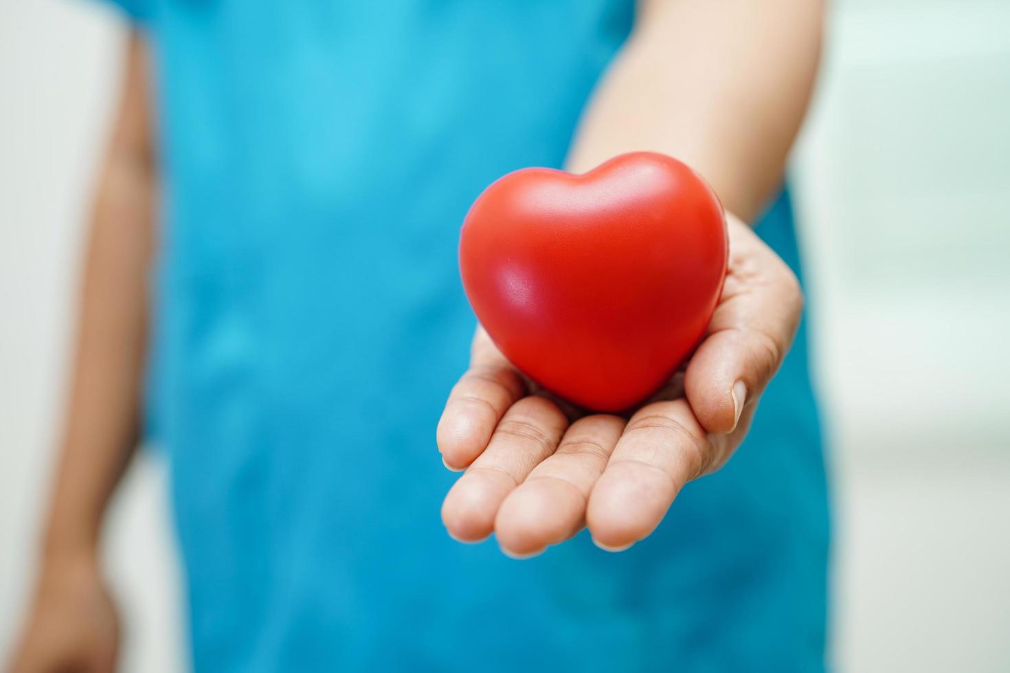 Asian woman doctor holding red heart for health in hospital. photo