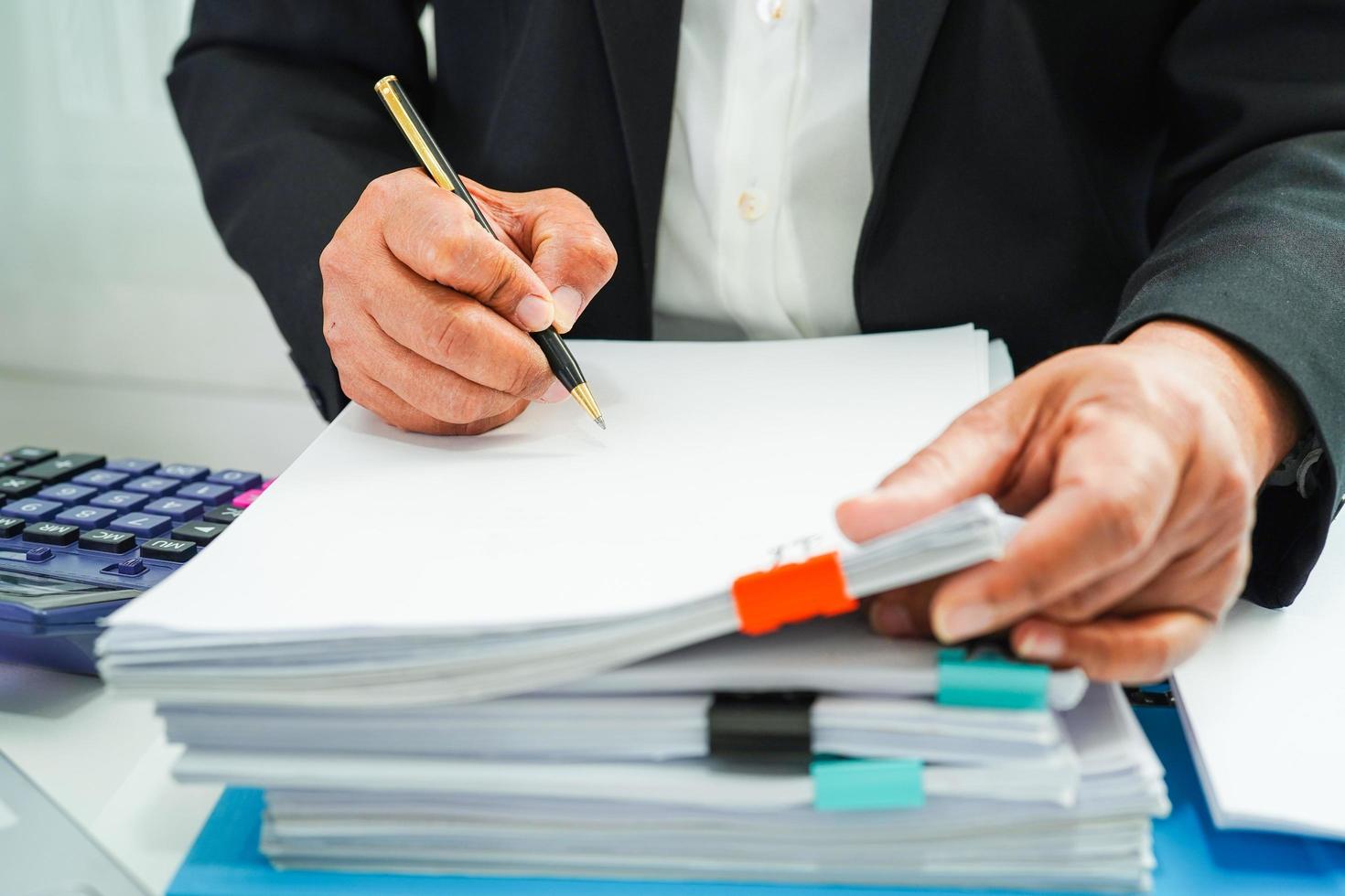 el empresario trabaja y prepara los datos del informe de papeleo para analizar la información en la carpeta de archivos en la oficina. foto