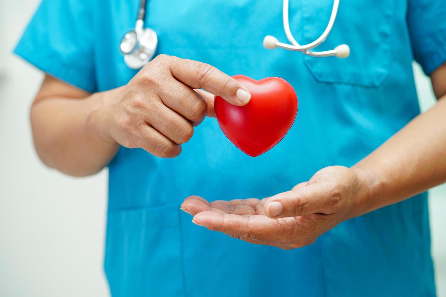 Asian woman doctor holding red heart for health in hospital. photo