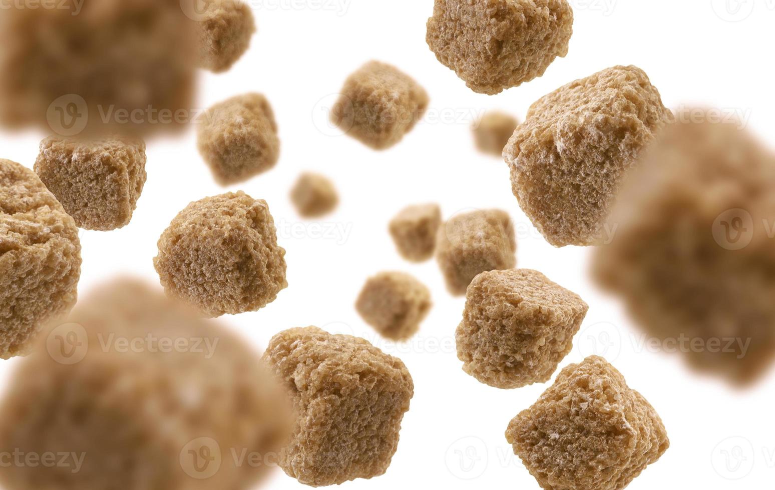 Brown cane sugar levitates on a white background photo