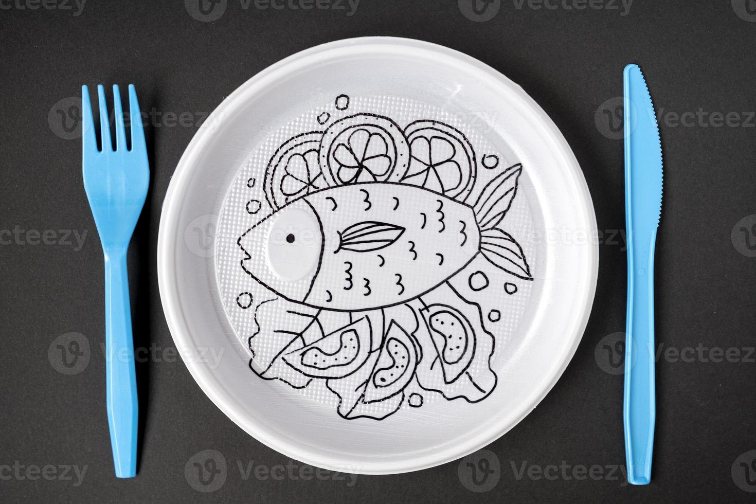 White plastic plate with cartoon doodle drawing on black background. Creative minimalistic food concept, top view. photo