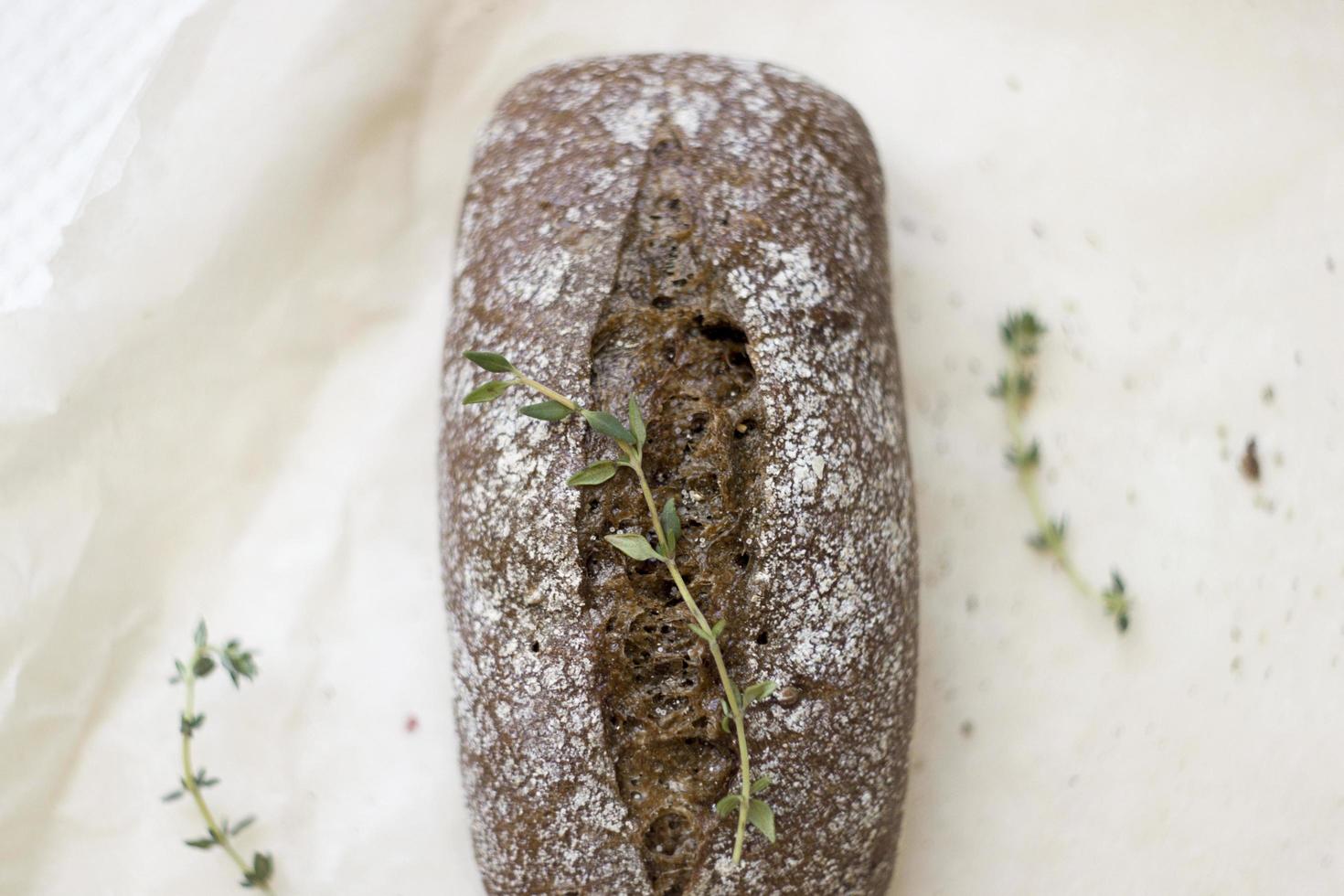 French baguettes with thyme on kraft paper. Mini baguette bread. Top view food, close up photo