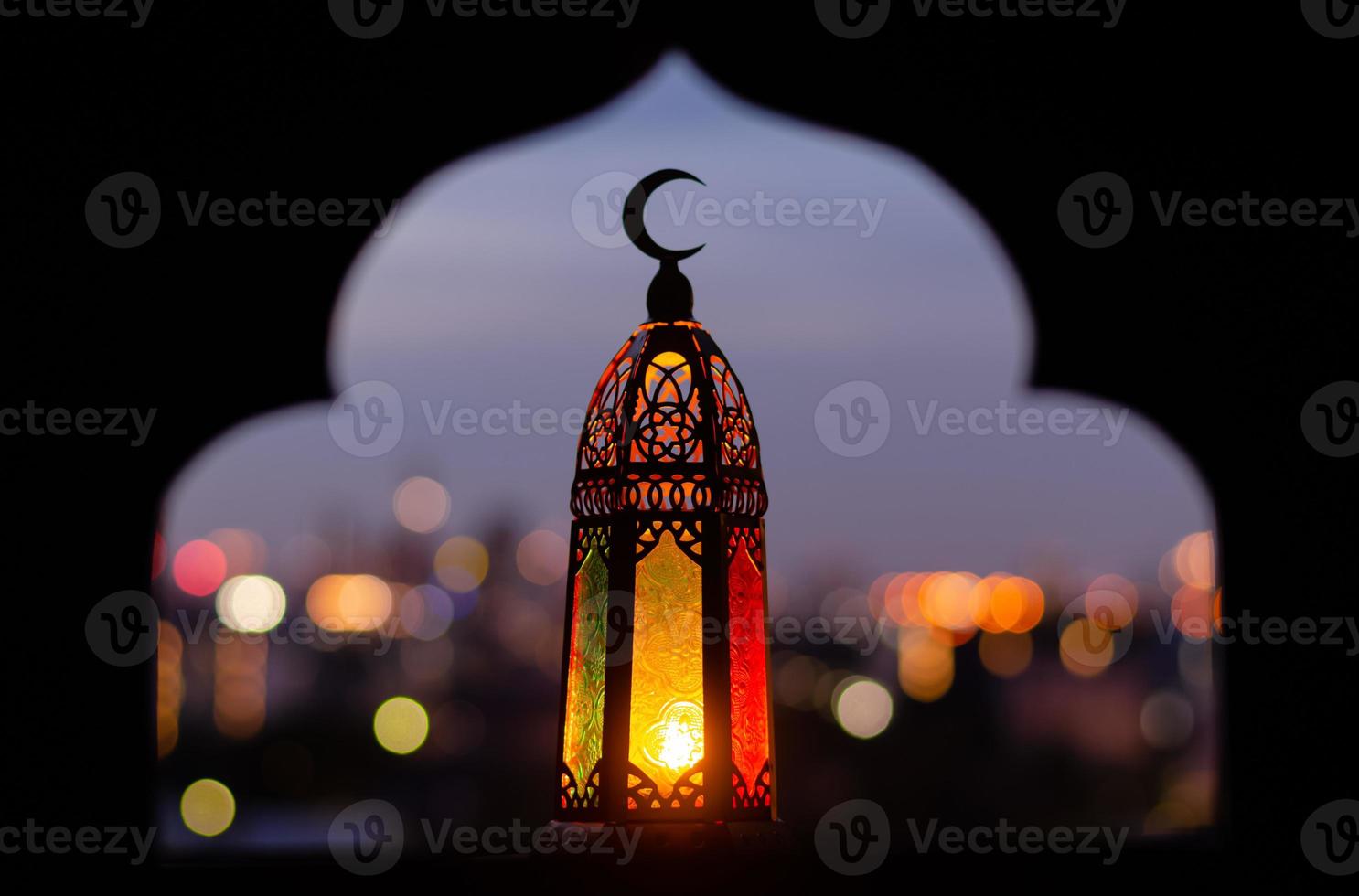 Lantern that have moon symbol on top with blurred focus of paper cut for mosque shape background. photo
