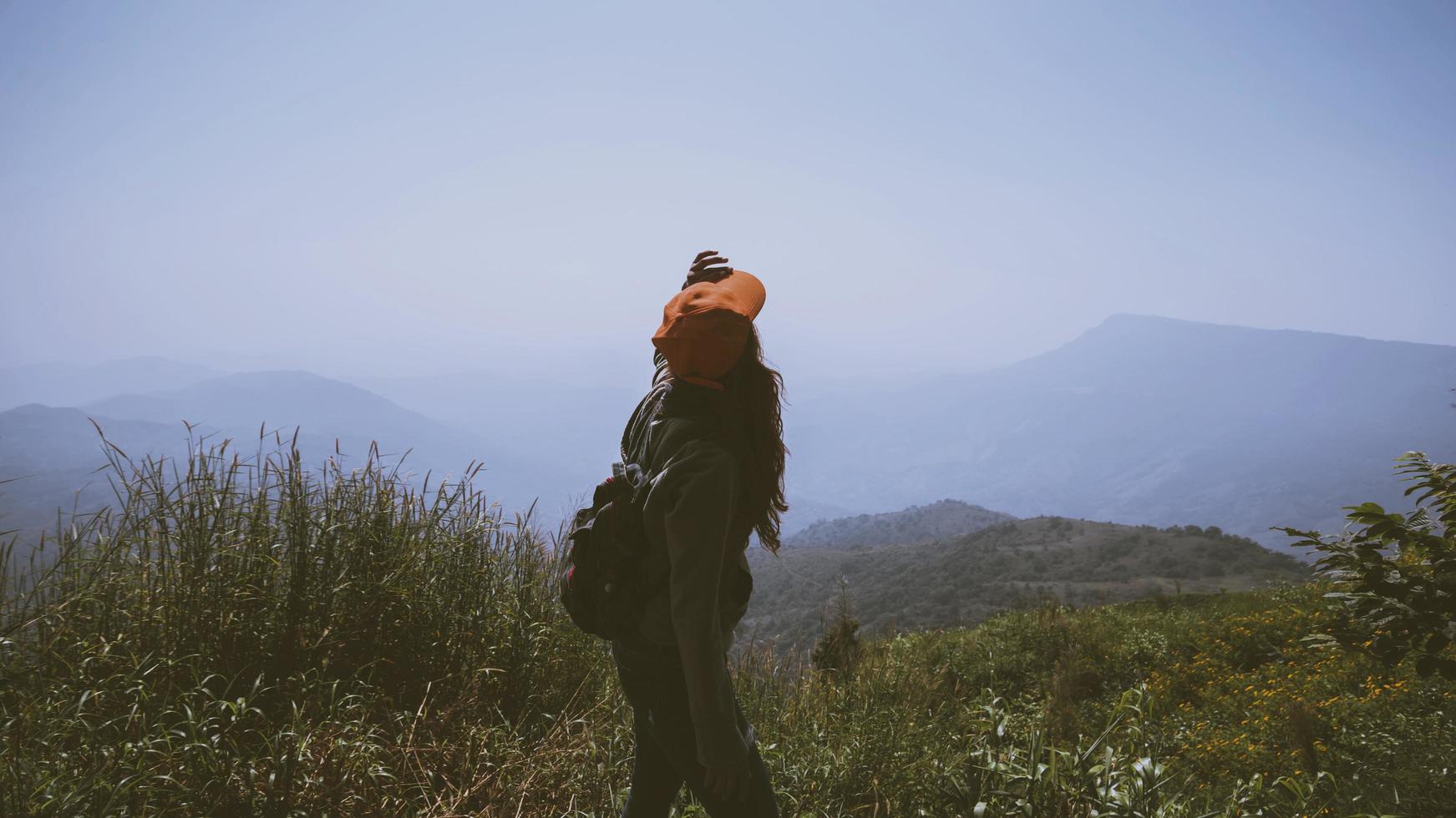 Asian women travel relax in the holiday.  Stand and watch landscape on the Moutain. Mountain Park happily. In Thailand photo