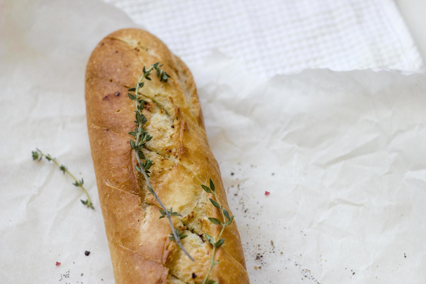 French baguettes with thyme on kraft paper. Mini baguette bread. Top view food, close up photo