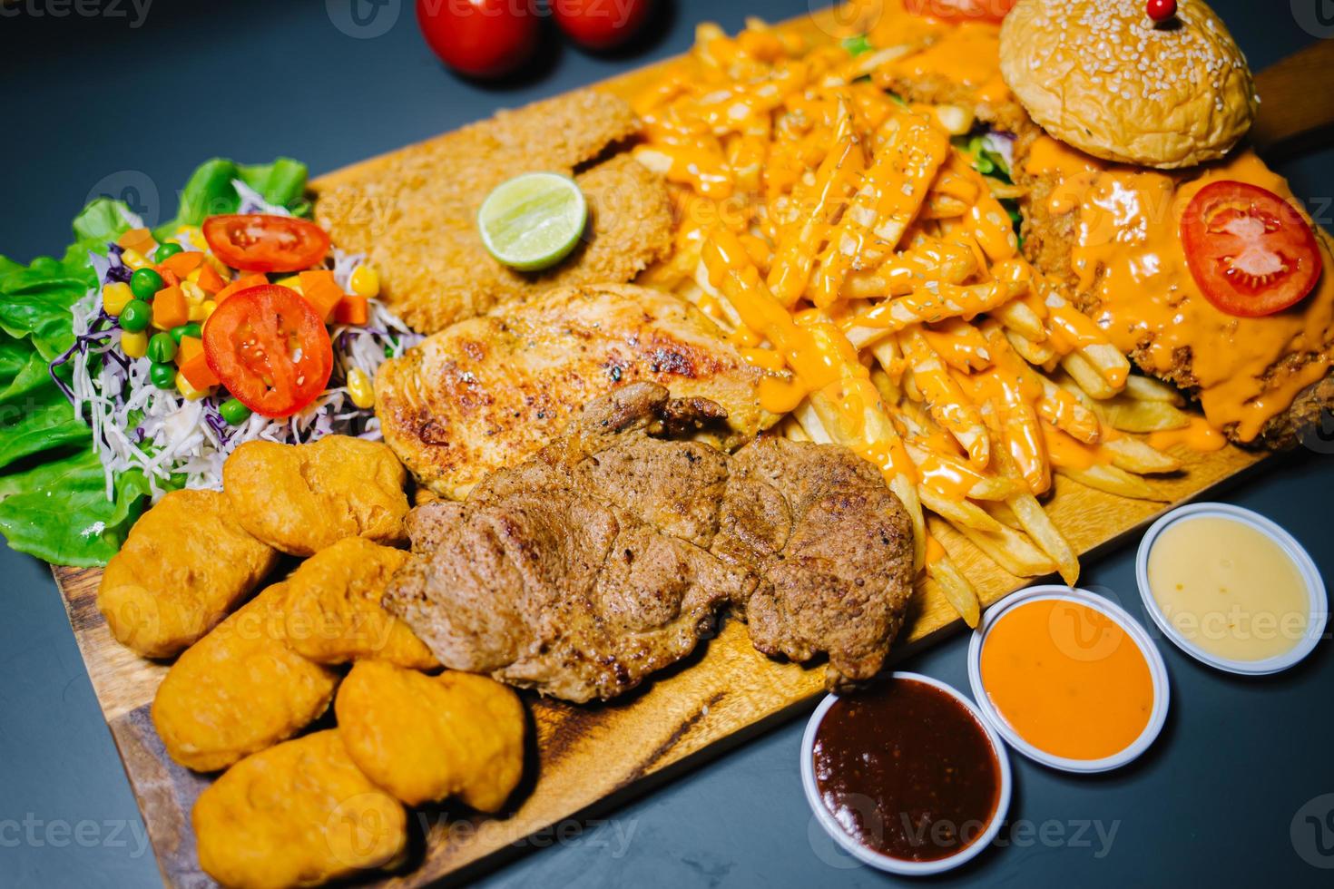 Grilled steak and lettuce, French fries on wooden plate photo