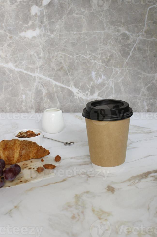 taza de café artesanal con croissant sobre fondo blanco foto