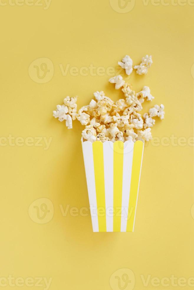 Spilled popcorn and paper bucket on background. Movie night concept. Copy space for text photo