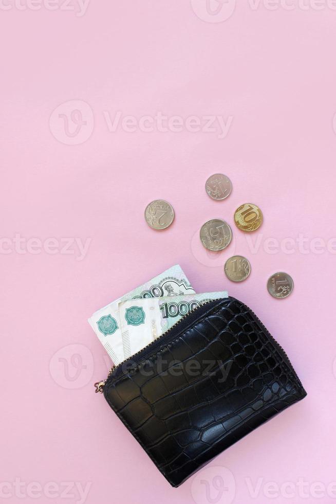 Russian rubles in the wallet on a pink background. Thousand notes and various coins. Place for text. Copy space. background for economic news. photo