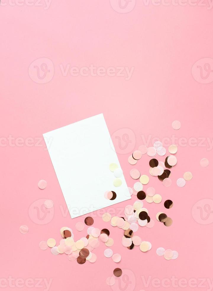 Pink confetti on pastel pink paper background. Festive holiday backdrop. Birthday congratulations Christmas New Year. Valentines Day. Flat lay, top view, copy space. photo