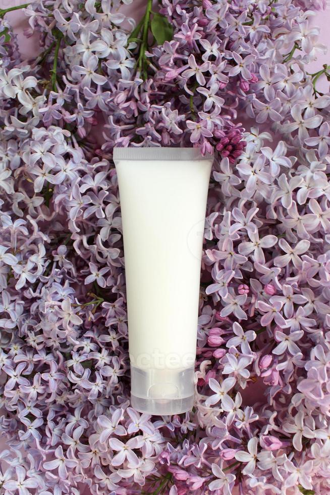 Top view of laying lilac flowers lying on the table, spring has come, copy space purple background. Lilac blossom, spring cosmetics for face and hands photo