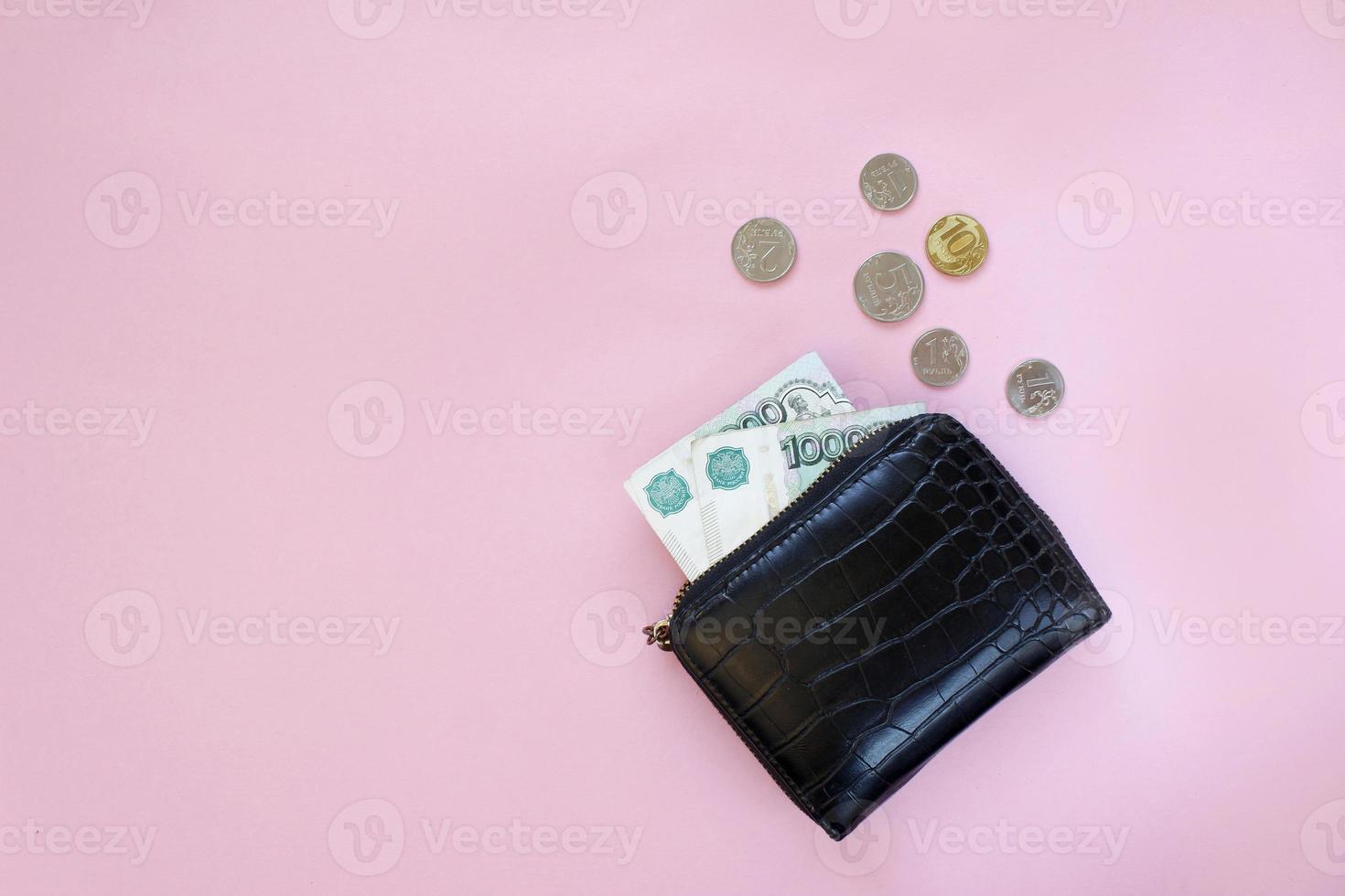 Russian rubles in the wallet on a pink background. Thousand notes and various coins. Place for text. Copy space. background for economic news. photo