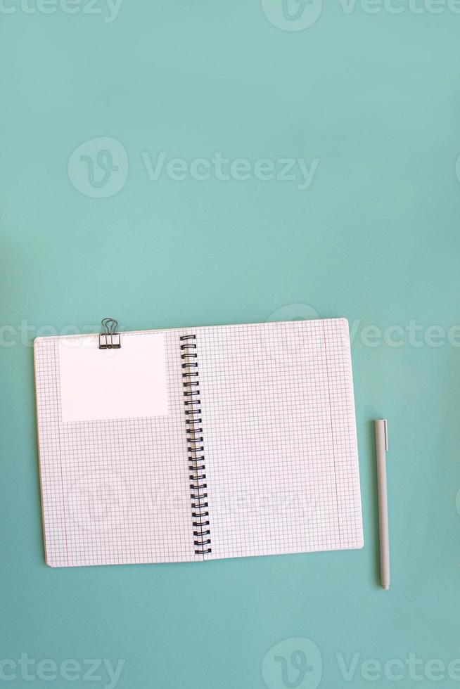 Blank notebook for writing on spirals on a blue background, flat lay, the end of motivation, business, building goals with negative industrial space and copy space photo