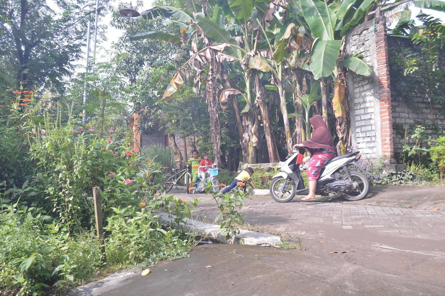 gresik, java oriental, indonesia, 2022 - el estado del pueblo por la mañana con un retrato de un niño pequeño jugando foto