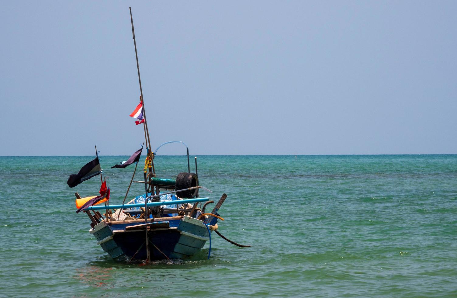 landscape look view Small fishing boat wooden old parked coast the sea. after fishing of fishermen in small village It small local fishery. Blue sky, white clouds, clear weather, Phala Beach, Rayong photo