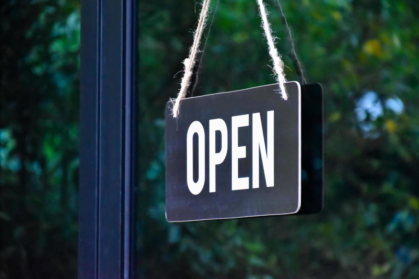 A shop label Open which hanging on the glass door of the shop, concept for informing people in Covid19 crisis situations around the world. photo