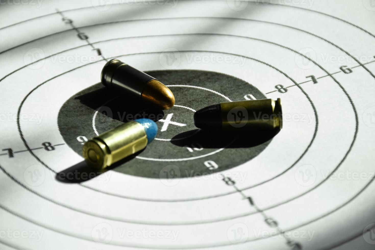 9mm bullets and 9mm bullet case on shooting target paper, soft and selective focus photo