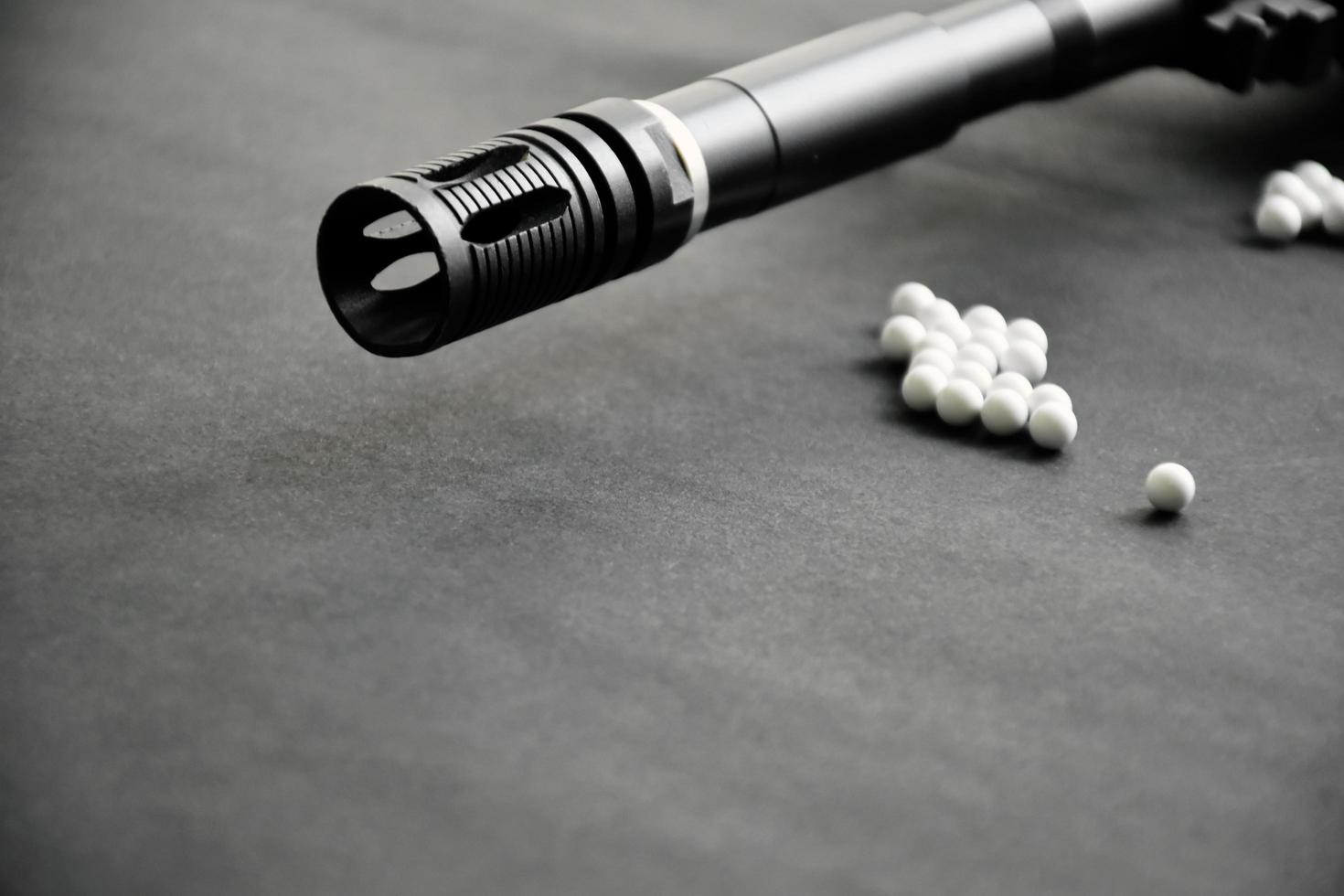 Closeup of white plastic bullets of airsoft gun or bb gun on wooden floor, soft and selective focus on white bullets. photo