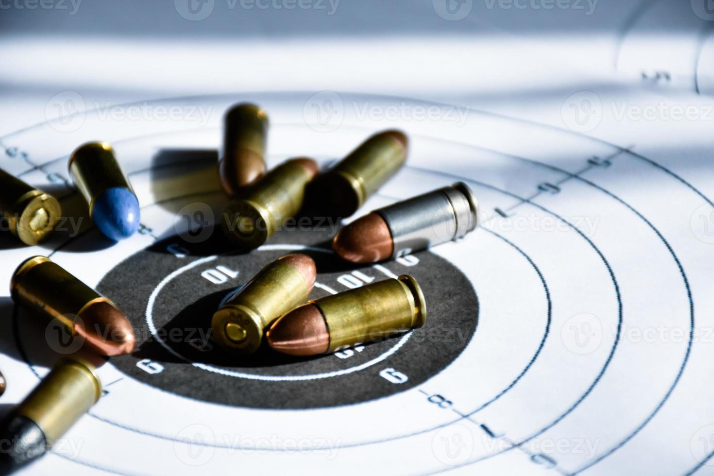 9mm bullets and 9mm bullet case on shooting target paper, soft and selective focus photo