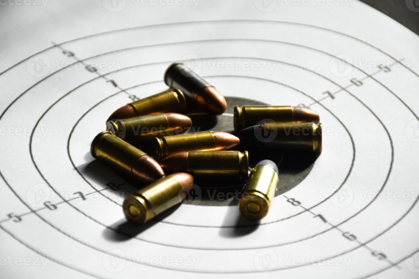 9mm bullets and 9mm bullet case on shooting target paper, soft and selective focus photo