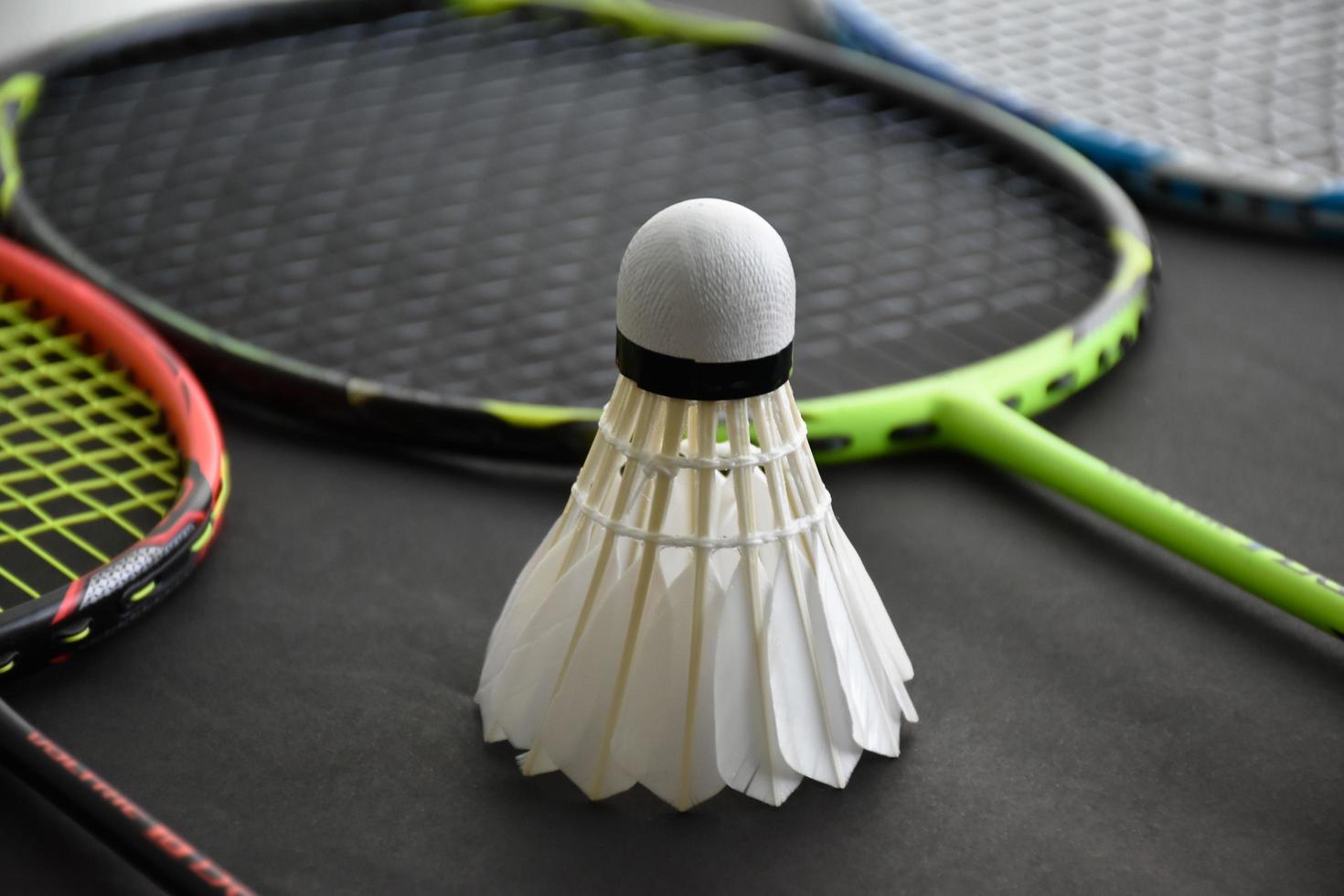 Badminton sports equipments, shuttlecocks, racket, grip, on floor of indoor badminton court. photo