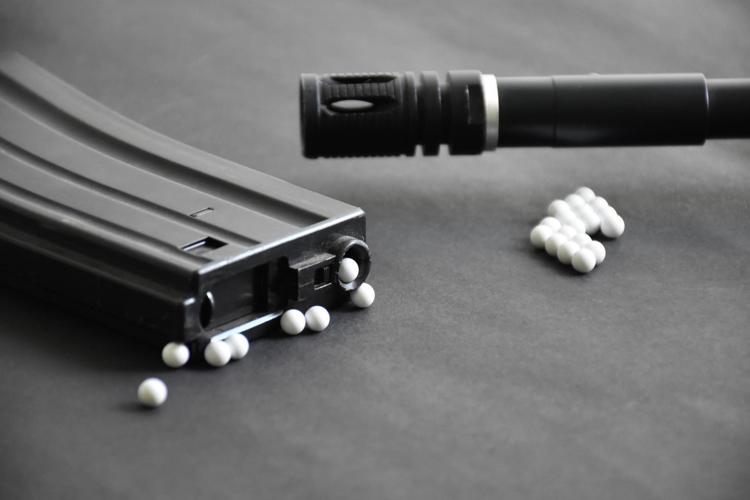 Closeup of white plastic bullets of airsoft gun or bb gun on wooden floor, soft and selective focus on white bullets. photo