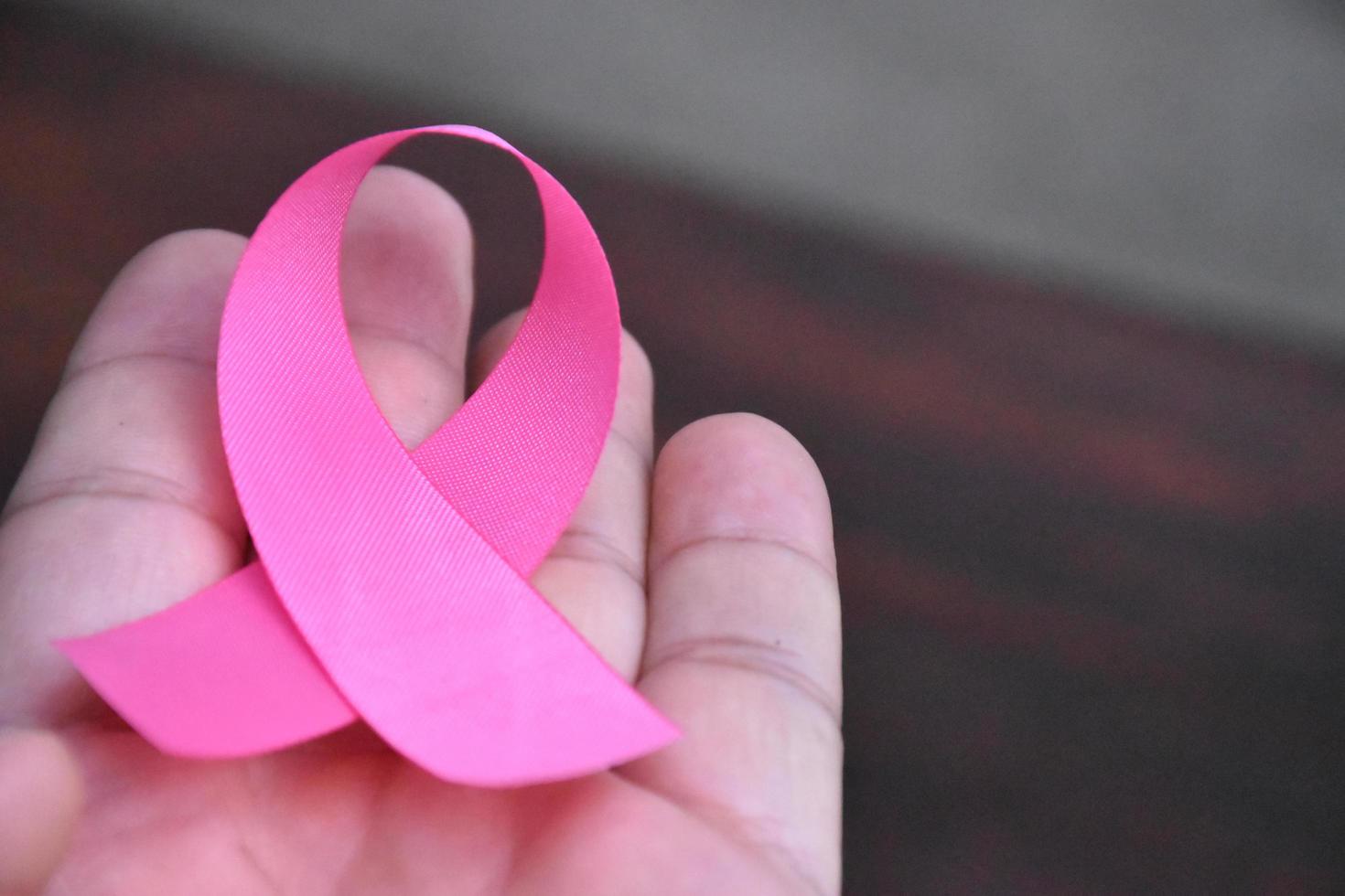 The pink ribbon in hand, a symbol of the global women's breast cancer campaign. photo