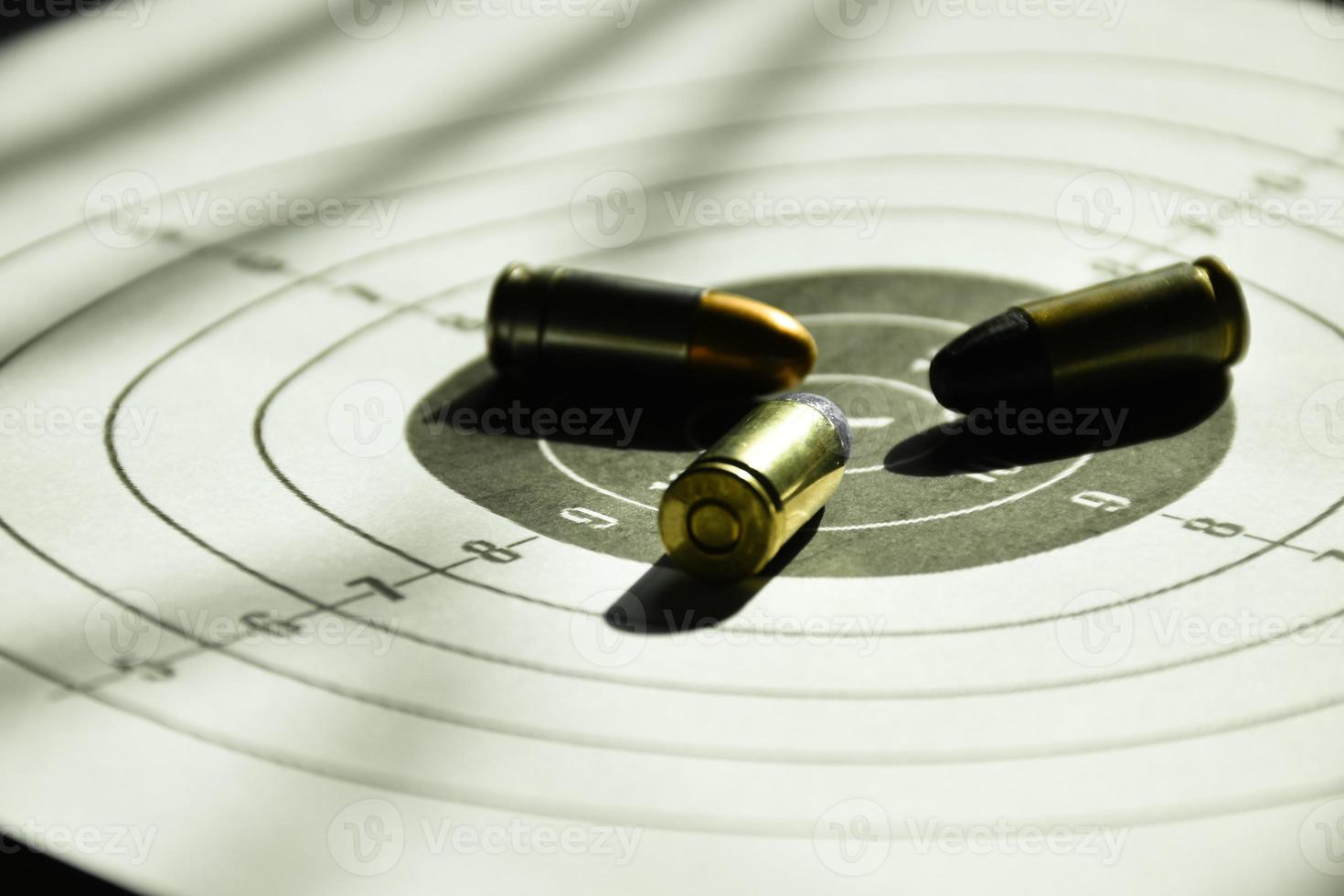 9mm bullets and 9mm bullet case on shooting target paper, soft and selective focus photo