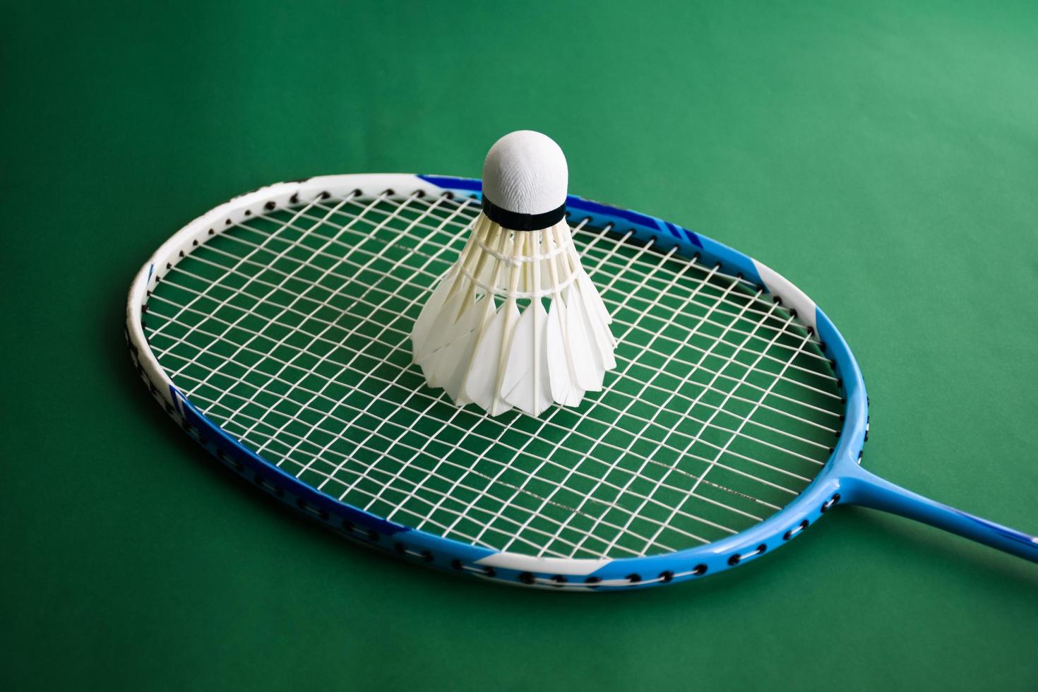 Badminton sports equipments, shuttlecocks, racket, grip, on floor of indoor badminton court. photo