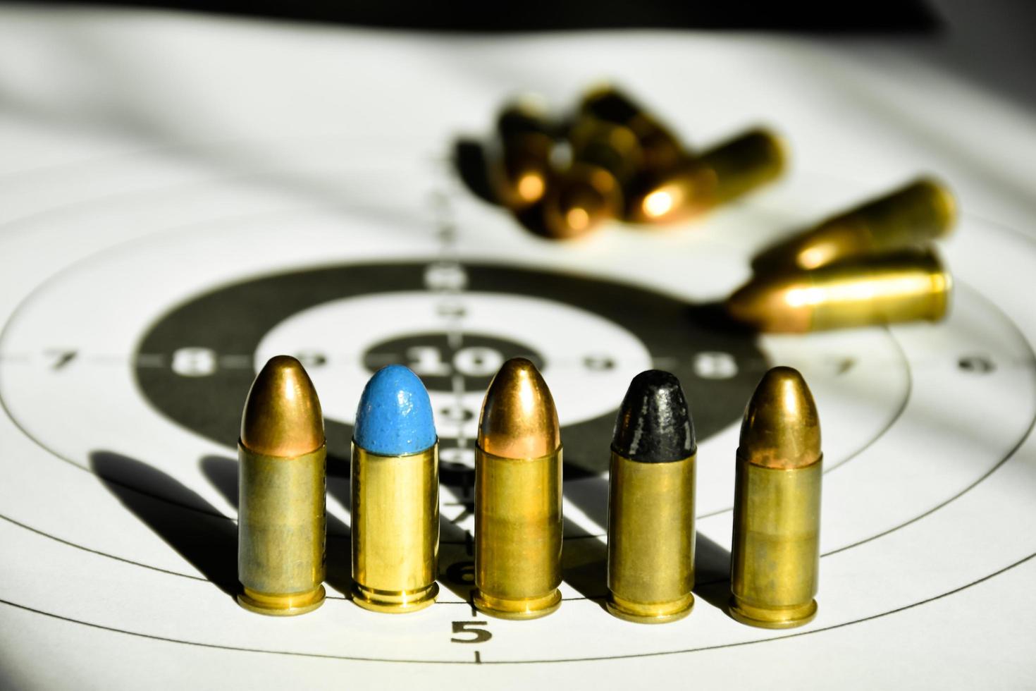 9mm bullets and 9mm bullet case on shooting target paper, soft and selective focus photo