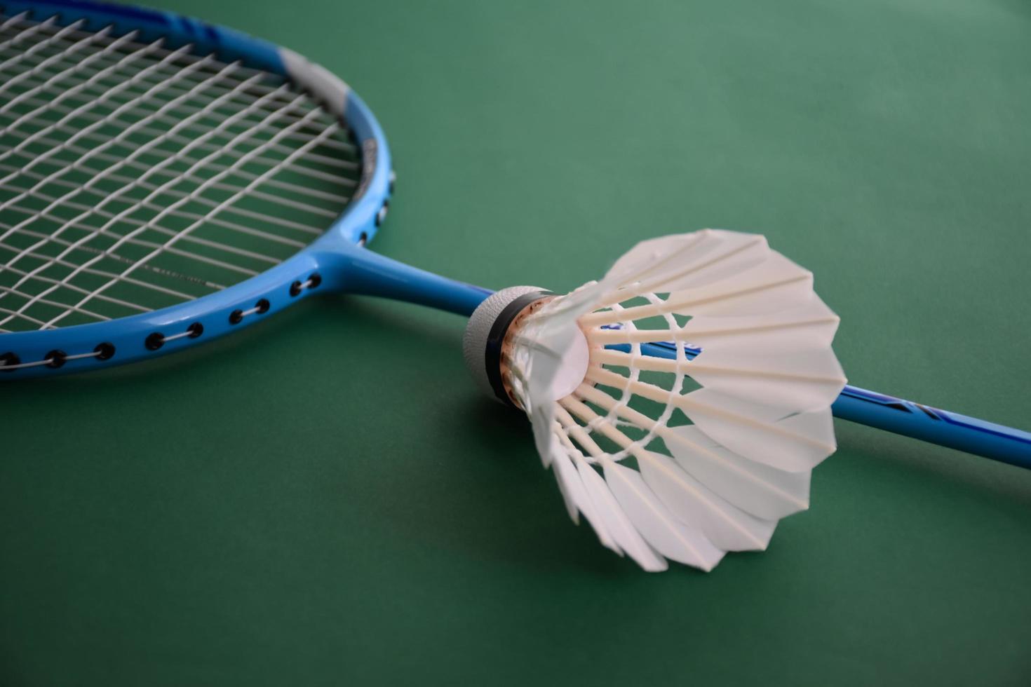 Badminton sports equipments, shuttlecocks, racket, grip, on floor of indoor badminton court. photo