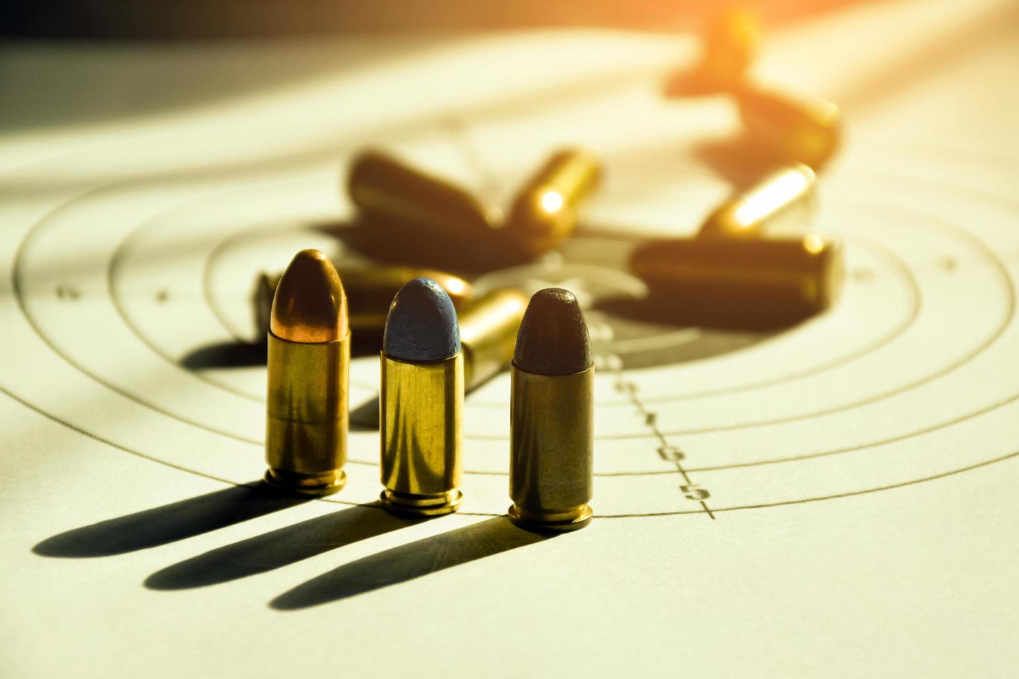 9mm bullets and 9mm bullet case on shooting target paper, soft and selective focus photo