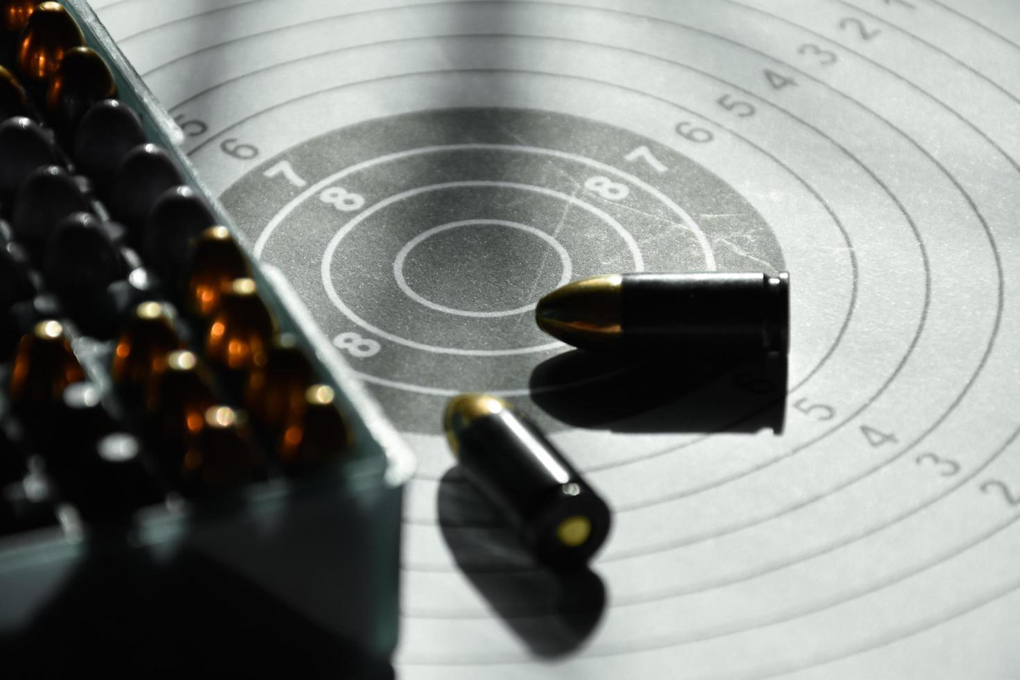 9mm bullets and 9mm bullet case on shooting target paper, soft and selective focus photo