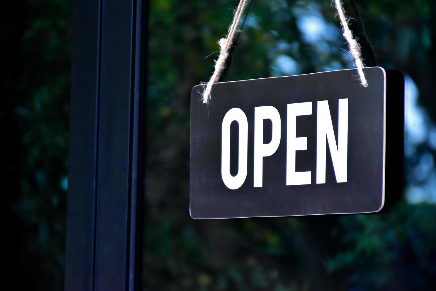 A shop label Open which hanging on the glass door of the shop, concept for informing people in Covid19 crisis situations around the world. photo